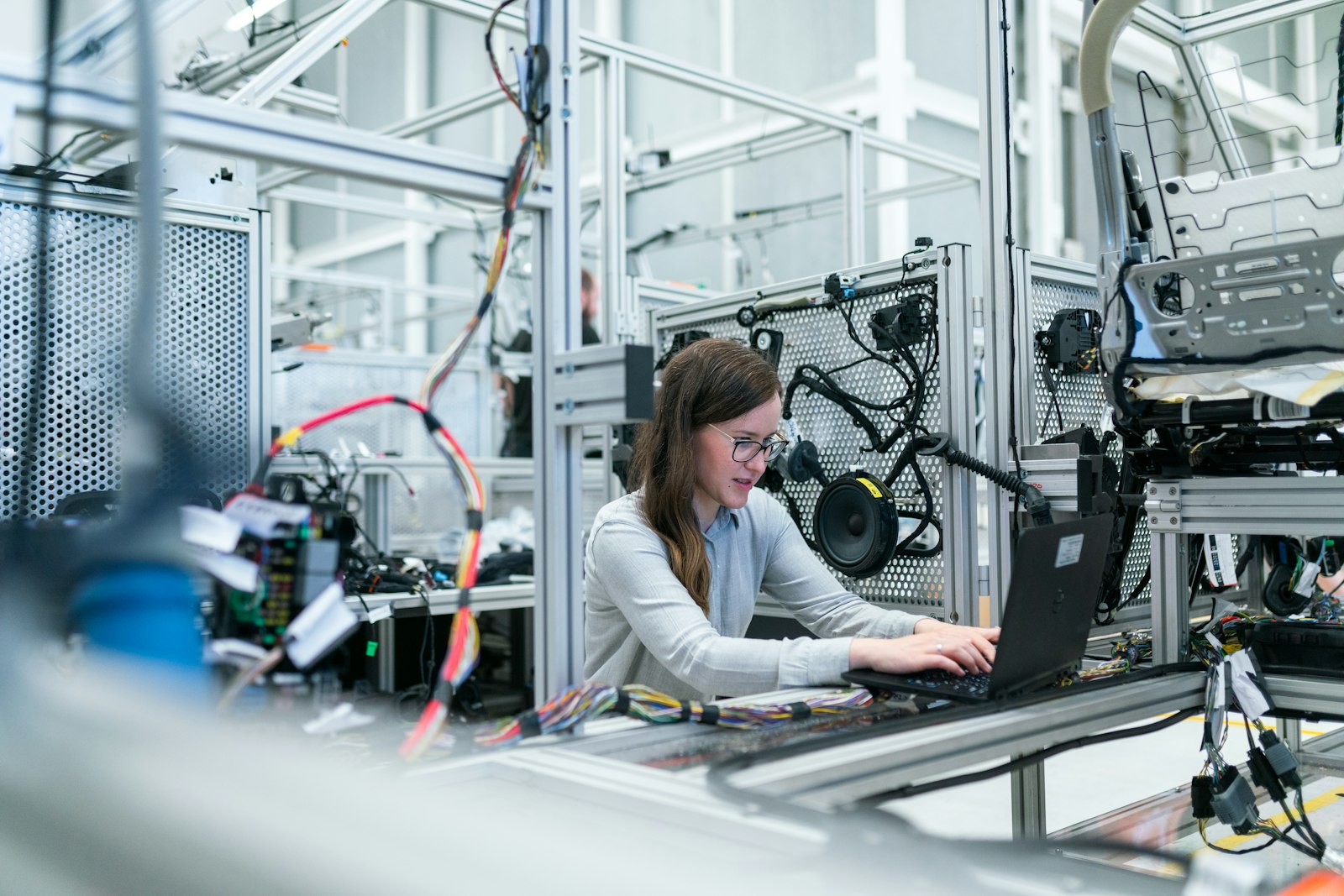 An engineer working at a laptop in a light-filled technical facility