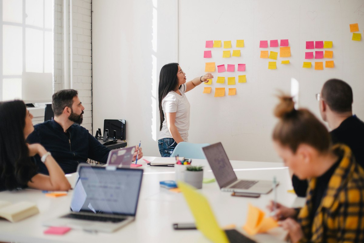 A facilitator walking a team through notes arranged on a wall