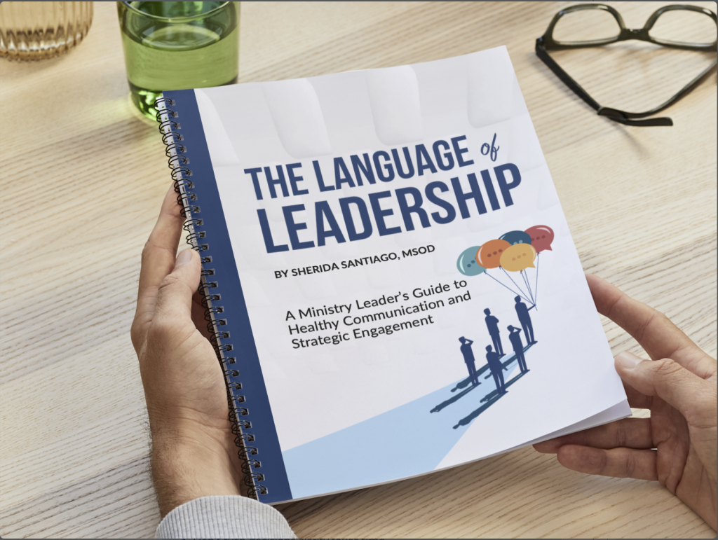 image of a person at a desk holding the Language of Leadership Book.